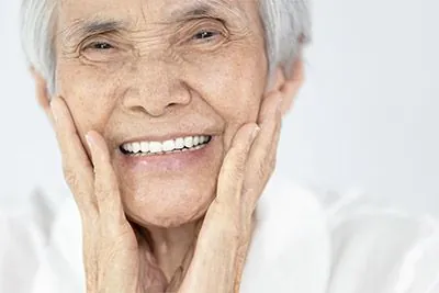 woman loving her smile after getting dental implants at Smiles Dental Center