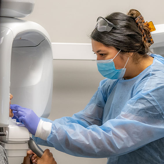Dental assistant prepping patient for CBCT scan
